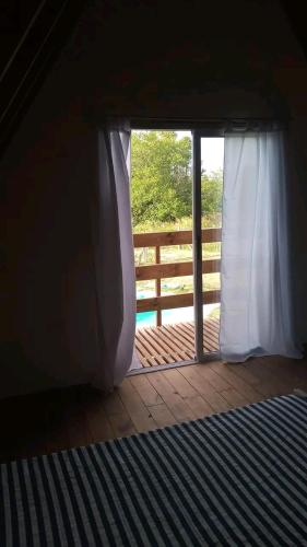 um quarto com uma porta com uma janela e uma cerca em La Alpina em Saladillo