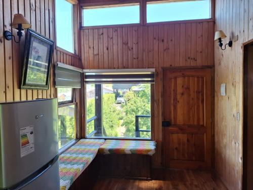 Habitación con banco en una habitación con ventana en Cabaña en Castro Chiloe, en Castro
