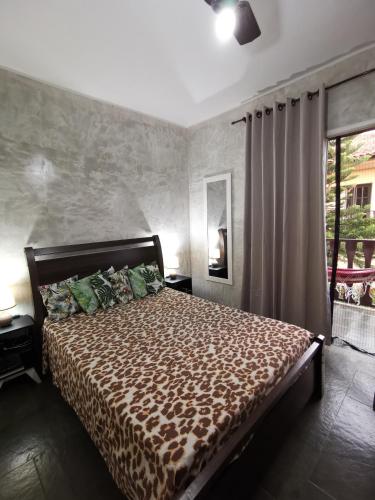 a bedroom with a bed and a large window at Flat Gorlaes in Araruama