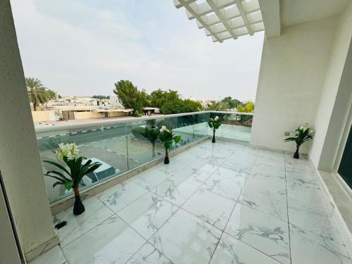 迪拜Single room with window near metro的一座带游泳池和植物的建筑的阳台