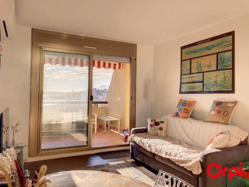 un salon avec un canapé et une grande fenêtre dans l'établissement Splendide 2 pièces climatisé avec piscine et garage privé - FR-1-647-6, à Menton