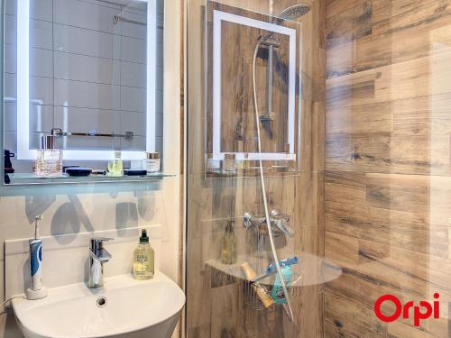 une salle de bain avec une douche avec un lavabo et un miroir dans l'établissement Splendide 2 pièces climatisé avec piscine et garage privé - FR-1-647-6, à Menton