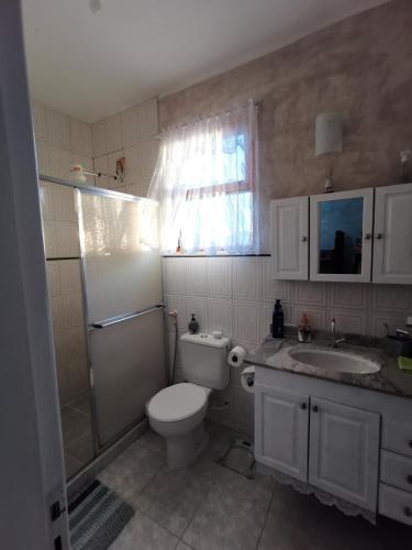 a bathroom with a toilet and a sink and a shower at Flat Gorlaes in Araruama
