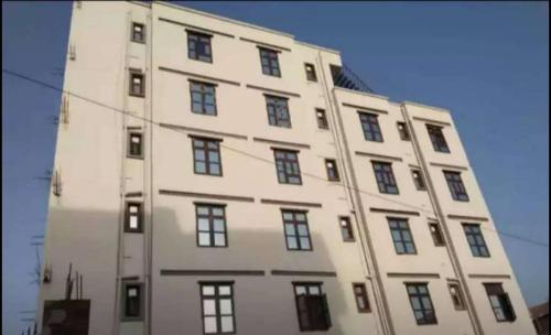 a tall white building with many windows on it at Shaurya Villa Guest House in Dānāpur