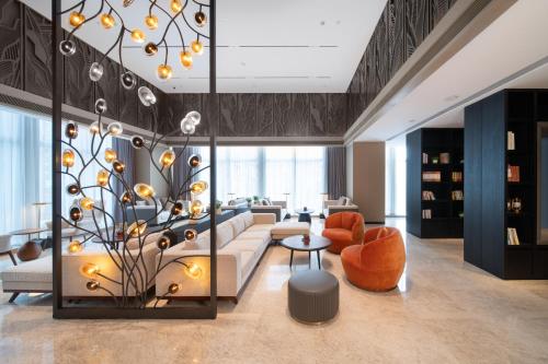 a living room with a couch and a table at Shan Zhi Ye Serviced Apartment Hotel - Houjie Wanda Plaza Liaoxia Subway Station in Dongguan