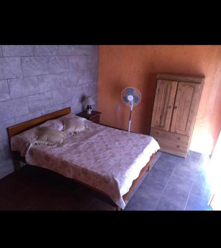 Un dormitorio con una cama y una lámpara. en Casa con pileta en icho cruz en Villa Icho Cruz