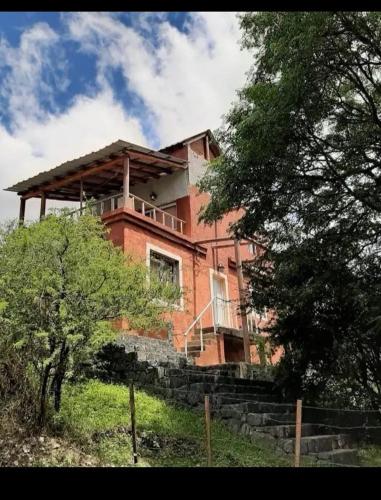 una gran casa de ladrillo en la cima de una colina en Casa con pileta en icho cruz en Villa Icho Cruz