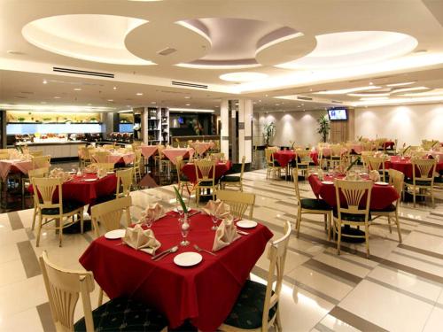 a restaurant with red tables and chairs in a room at GBW Hotel in Johor Bahru