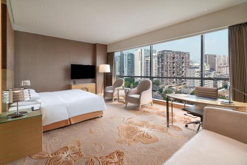 pokój hotelowy z łóżkiem i dużym oknem w obiekcie Renaissance Chengdu Hotel w mieście Chengdu