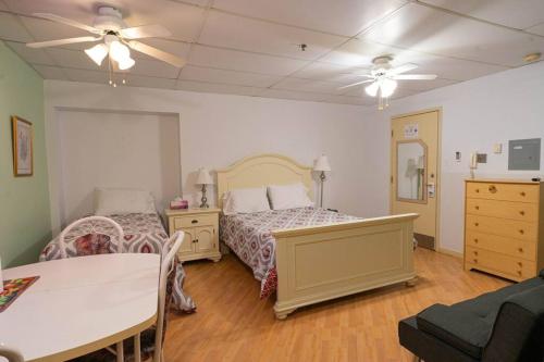 三河城的住宿－223 Charmante chambre double，一间卧室配有两张床、一张桌子和吊扇。