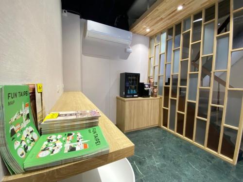 a room with a table with a book and a shelf at 宏洲旅社HZ Hotel in Taipei