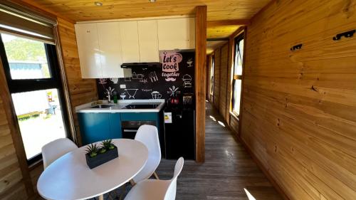 a kitchen with a table and chairs and a refrigerator at Puerta austral in Puelo