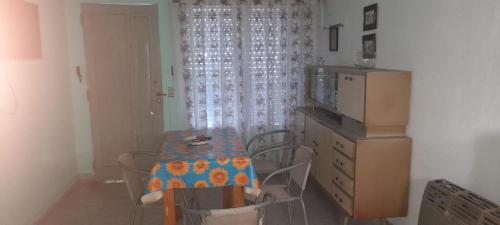 comedor con mesa y sillas y cocina en Departamentos Doña Viya en Ramallo