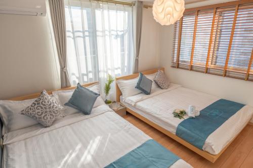 a bedroom with two beds and a chandelier at 桜の川9 Ikebukuro Villa Free parking More than 15 people donki Large TV in Tokyo