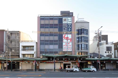 two trucks are parked in front of a building at Sauna & Capsule Hotel Rumor Plaza in Kyoto