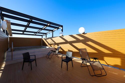a patio with chairs and a table on a deck at Sauna & Capsule Hotel Rumor Plaza in Kyoto