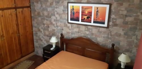 1 dormitorio con 1 cama con 2 lámparas y una foto en la pared en Chalet con piscina en San Luis, en San Luis