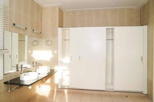 a bathroom with three sinks and a large sliding glass door at Bougainvillea Sealinks City PC16-17-18 in Ấp Phú Tịnh (2)