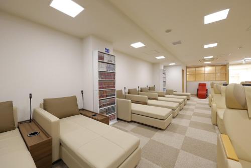 a waiting room with a row of couches at Sauna & Capsule Hotel Rumor Plaza in Kyoto