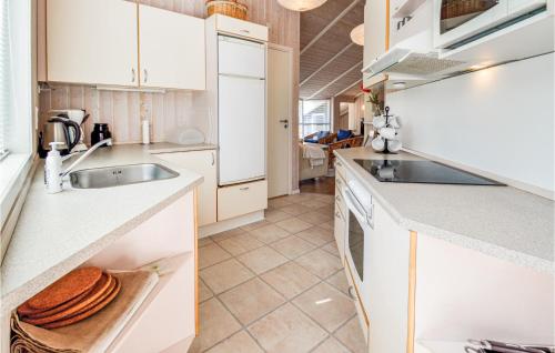 a kitchen with white cabinets and a sink at Three-Bedroom Holiday Home In Rodby in Rødby