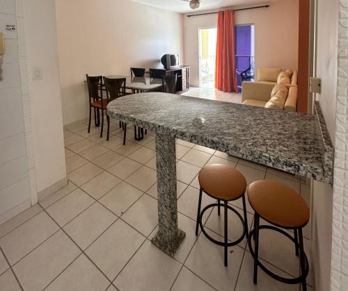 a kitchen and living room with a granite counter top at Jardins das Thermas - Vista para Piscina - Nascente in Caldas Novas