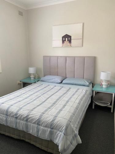 ein Schlafzimmer mit einem großen Bett mit zwei Tischen in der Unterkunft Evans Bed and Breakfast in Lakeside