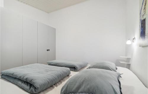 two beds in a room with white walls at Cozy Apartment In Nex With Kitchen in Neksø