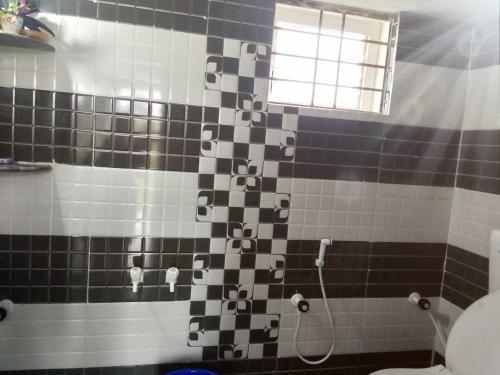 een badkamer met een douche met zwarte en witte tegels bij Bethel guest house in Sūlagiri