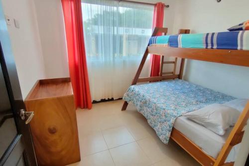 1 dormitorio con 2 literas y ventana en Coastal Casita, en Bejuco