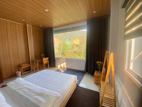 a bedroom with a bed and a large window at Bảo Lạc - Sunny Homestay in Bảo Lạc
