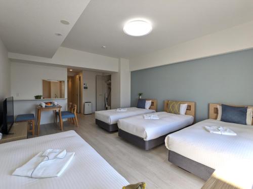 a hotel room with two beds and a television at ESLEAD HOTEL Osaka Tsuruhashi in Osaka