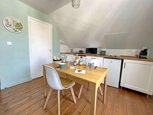 une petite cuisine avec une table et des chaises en bois dans l'établissement Studio Rénové 16m² au Cœur de Berck Plage - Tout Équipé avec Wifi - FR-1-646-56, à Berck-sur-Mer