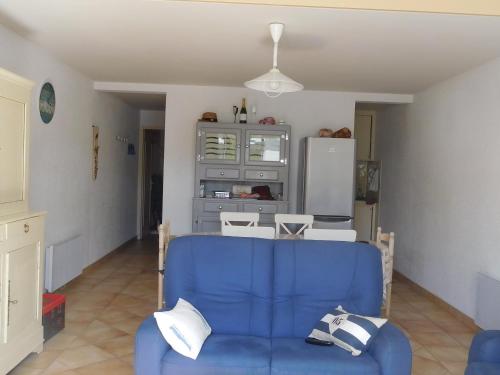 un salon avec un canapé bleu et des chaises dans l'établissement Charmante maisonnette près de la plage, 6 pers, équipements complets, parking privé, La Faute-sur-Mer - FR-1-476-205, à La Faute-sur-Mer