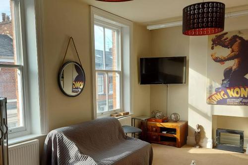 a living room with a tv and a chair at Large 2 Bedroom City Centre Apartment + Parking in Preston