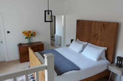 a bedroom with a large bed with a wooden headboard at Large 2 Bedroom City Centre Apartment + Parking in Preston