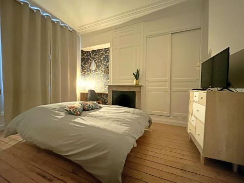 - une chambre avec un lit, une télévision et une cheminée dans l'établissement Charmant Studio au Coeur de Berck Plage, à 5 min de la Mer - FR-1-646-57, à Berck-sur-Mer