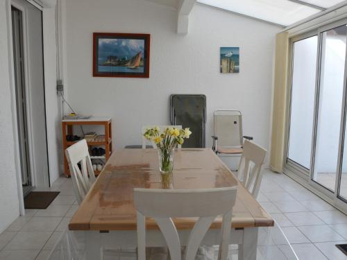 une salle à manger avec une table et des chaises en bois dans l'établissement Maison Confortable à 300m de la Plage avec Terrasse et Parking - FR-1-323-432, à Saint-Jean-de-Monts
