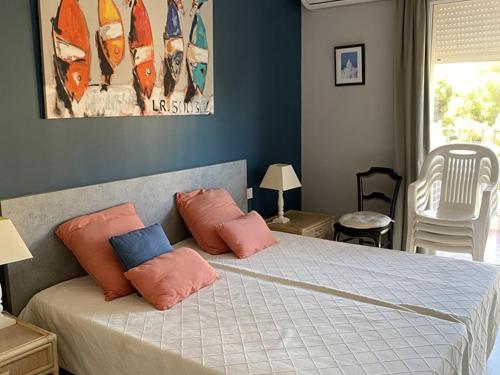 - une chambre avec un lit doté d'oreillers roses et bleus dans l'établissement Appartement climatisé avec terrasses et vue port, proche plages à Hyères - FR-1-335-191, à Hyères