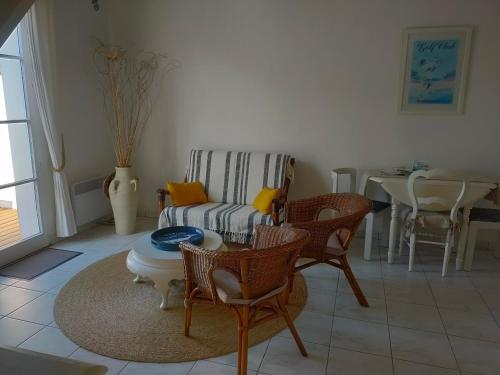 un salon avec un canapé, des chaises et une table dans l'établissement Maison 6 pers, terrasse sur plan d'eau, proche plage, golf, centre et commodités - FR-1-323-474, à Saint-Jean-de-Monts