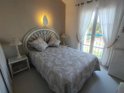 une chambre avec un lit avec une grande fenêtre dans l'établissement Maison 6 pers, terrasse sur plan d'eau, proche plage, golf, centre et commodités - FR-1-323-474, à Saint-Jean-de-Monts