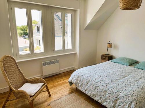 une chambre avec un lit, une chaise et une fenêtre dans l'établissement Appartement Confort à Bénodet: Plage et Commerces à Pied, Parking Privé, 4 Pers. - FR-1-481-152, à Bénodet