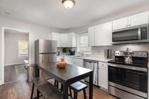 a kitchen with a table with a vase on it at Downtown home! Walk to Bulls Stadium, DPAC & food in Durham