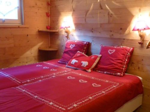- un lit rouge dans une chambre en bois avec deux lampes dans l'établissement Appartement skis aux pieds 4 pers avec terrasse ensoleillée - L'Alpe d'Huez - FR-1-405-348, à Huez
