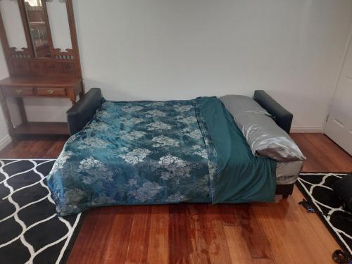 a bed sitting in a living room with a bedspread at Cock or Two Kink House in Cockatoo