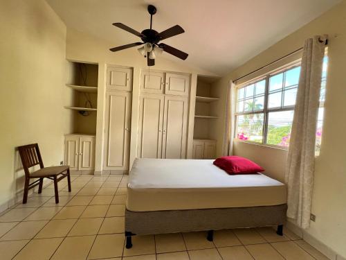 1 dormitorio con 1 cama y ventilador de techo en SAM TRAVEL en Managua