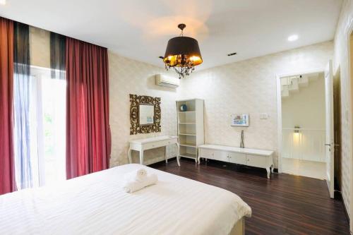 una camera con letto bianco e specchio di Maison Villa Orchid Phú Mỹ Hưng ad Ho Chi Minh