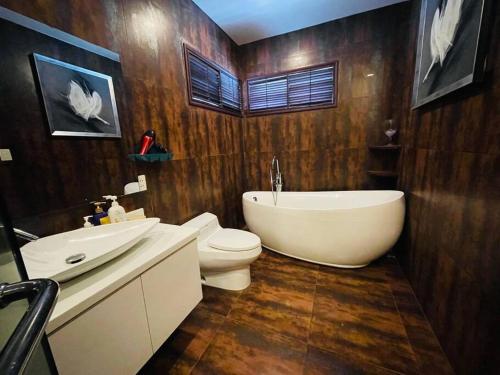 La salle de bains est pourvue d'une baignoire, de toilettes et d'un lavabo. dans l'établissement Maison Villa Orchid Phú Mỹ Hưng, à Hô-Chi-Minh-Ville