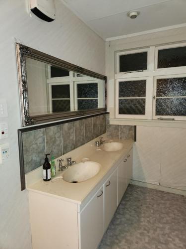 un bagno con due lavandini e due finestre di Quirky Villa a Whanganui