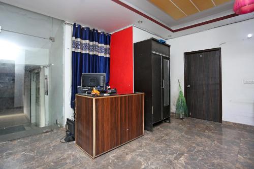 a room with a tv and a red wall at OYO Hotel Kohinoor in New Delhi
