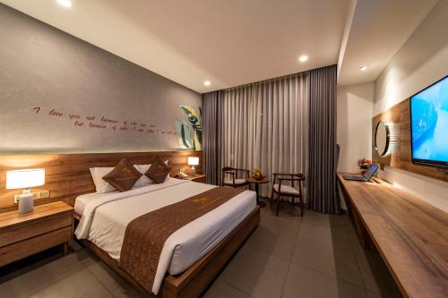 a hotel room with a bed and a tv at Thanh Long Hotel - Tra Khuc in Ho Chi Minh City